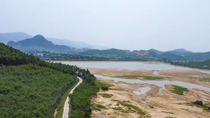 Con đường dẫn vào hồ Khe Nhòi uốn lượn qua những triền đồi thấp, mang lại cảm giác thư thái cho bất kỳ ai muốn tìm về với thiên nhiên.